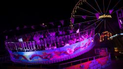 Fotografie Experimente mit Licht und Bewegung August 2022 Nachtansicht einer beleuchteten Fahrgeschäftsattraktion auf einem Jahrmarkt