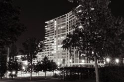 Gallus Viertel Frankfurt Street- und Architekturfotohrafie Ein modernes Wohngebäude, das nachts von Bäumen umgeben ist Gallus Viertel Frankfurt Street- und Architekturfotohrafie Moderne Wohnanlage bei Nacht mit beleuchteten Fenstern in Schwarzweiß