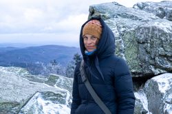 Landschaftsfotografie Großer Feldberg Taunus Winter Januar 2025 Frau in Winterjacke auf einem verschneiten Berg mit weitem Talblick