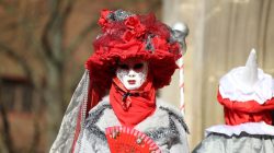 Halla Venezia Schwäbisch Hall Februar 2023 Ein farbenprächtiges venezianisches Kostüm mit eleganter Maske und roten Accessoires Halla Venezia Schwäbisch Hall Februar 2023 Person in rotem venezianischen Karnevalskostüm mit Maske und Fächer