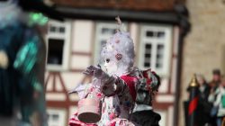 Halla Venezia Schwäbisch Hall Februar 2023 Eine Figur in aufwendigem venezianischen Kostüm posiert vor historischer Architektur Halla Venezia Schwäbisch Hall Februar 2023 Traditionelle venezianische Maskerade vor Fachwerkgebäude