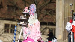 Halla Venezia Schwäbisch Hall Februar 2023 Eine Karnevalsfigur trägt ein kunstvolles Kostüm mit einem mehrstöckigen Kuchenständer Halla Venezia Schwäbisch Hall Februar 2023 Karneval Figur in pinkem Kostüm mit Kuchenständer