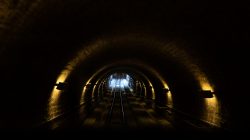 Heidelberg Natur- Architekturfotografie Dunkler Tunnel mit Bahngleisen und schwacher Beleuchtung