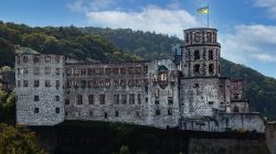Heidelberg Natur- Architekturfotografie Heidelberger Schloss mit ukrainischer Flagge, umgeben von Wald