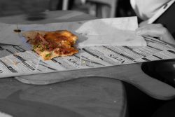 Heidelberg Natur- Architekturfotografie Halb gegessene Pizza auf Zeitung mit Wespe