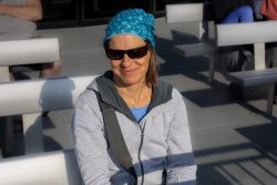 Helgolandreise August 2023 Frau mit Sonnenbrille genießt sonniges Wetter Helgolandreise August 2023 Frau mit Sonnenbrille und blauer Kopfbedeckung lächelt in der Sonne