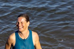 Helgolandreise August 2023 Eine Frau genießt einen sonnigen Tag im Wasser. Helgolandreise August 2023 Frau im blauen Badeanzug lächelt im offenen Wasser in der Sonne