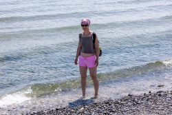 Helgolandreise August 2023 Entspannt an einem sonnigen Küstentag Helgolandreise August 2023 Frau mit rosa Shorts und Sonnenbrille steht am kieseligen Strand