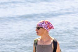 Helgolandreise August 2023 Eine Frau genießt den Blick auf das Meer begleitet von einer ruhigen Atmosphäre Helgolandreise August 2023 Frau mit Sonnenbrille und Kopftuch am Meer