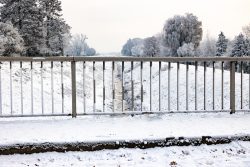 Landschaftsfotografie Winter Gernsheim Dezember 2022 Ein ruhiger Wintertag mit Blick auf einen zugefrorenen Fluss hinter einem Zaun Landschaftsfotografie Winter Gernsheim Dezember 2022 Winterlandschaft mit schneebedecktem Fluss hinter einem Metallzaun