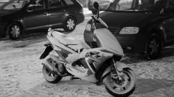 Landschaftsfotografie Winter Gernsheim Dezember 2022 Ein Motorroller ist auf einem verschneiten Parkplatz abgestellt. Landschaftsfotografie Winter Gernsheim Dezember 2022 Verschneiter Motorroller auf verschneitem Parkplatz im Winter