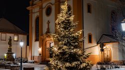 Landschaftsfotografie Winter Gernsheim Dezember 2022 Ein Weihnachtsbaum mit Lichtern steht vor einer Kirche in einer verschneiten Nacht Landschaftsfotografie Winter Gernsheim Dezember 2022 Beleuchteter Weihnachtsbaum vor Kirche in verschneiter Nacht
