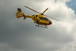 Loreley - Fotoserie - Landschaftsfotografie - Aloys Peter Trenz Gelber ADAC-Rettungshubschrauber fliegt am bewölkten Himmel