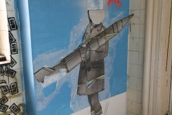 Lost Places Fotografie - Altes Polizeipräsidium Frankfurt Streetart eines gesichtslosen Kriegers mit Rakete auf blauer Wand