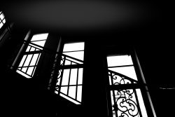 Lost Places Fotografie - Altes Polizeipräsidium Frankfurt Schattenhafte Treppenhaus-Silhouette mit kunstvollen Geländern