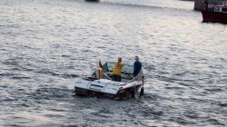 Mainuferfest Frankfurt Fotoserie Aloys Peter Trenz August 2022 Zwei Personen auf einem Motorboot mit deutscher Flagge auf einem Fluss