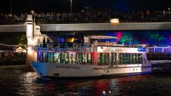 Mainuferfest Frankfurt Fotoserie Aloys Peter Trenz August 2022 Beleuchtetes Flussschiff unter einer Brücke bei Nacht