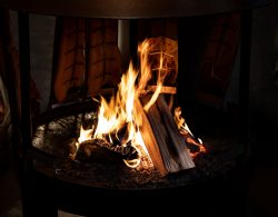 Mainz Weihnachtsmarkt Dezember 2023 Lagerfeuer mit lodernden Flammen und umgedrehtem Fisch zum Räuchern