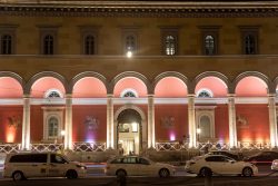 München Fotografie Aloys Peter Trenz Architektur Nächtliche Ansicht einer beleuchteten Fassade mit Bögen und vorbeifahrenden Autos
