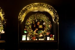 München Fotografie Aloys Peter Trenz Architektur Beleuchtetes Schaufenster mit Weihnachtsdekoration und Kranz