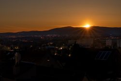 Nachtfotografie Light Painting Frankfurt Sonnenuntergang über einer städtischen Landschaft mit Hügeln im Hintergrund