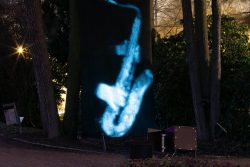 Palmengarten Frankfurt Winterlichter Januar 2022 Leuchtende Saxophon-Projektion zwischen Bäumen