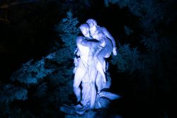 Palmengarten Frankfurt Winterlichter Januar 2022 Beleuchtete Marmorskulptur eines umarmenden Paares im Wald