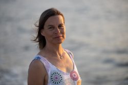 Portraitfotografie Fotoshooting Strand Helgoland August 2024 Frau in weißem Sommerkleid am Meer bei Sonnenuntergang