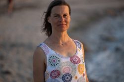 Portraitfotografie Fotoshooting Strand Helgoland August 2024 Frau in einem gemusterten Kleid am Strand bei Sonnenuntergang