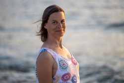 Portraitfotografie Fotoshooting Strand Helgoland August 2024 Frau am Strand bei Sonnenuntergang in einem bunten Kleid