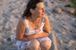 Portraitfotografie Fotoshooting Strand Helgoland August 2024 Frau in Sommerkleid blickt nachdenklich am Sandstrand