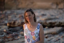 Portraitfotografie Fotoshooting Strand Helgoland August 2024 Frau im Sommerkleid am steinigen Strand