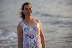 Portraitfotografie Fotoshooting Strand Helgoland August 2024 Frau am Meer mit geblümtem Sommerkleid bei Sonnenuntergang