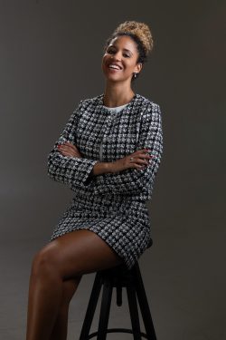 Portraitfotografie Studiofotografie Frau in modischem schwarz-weißem Anzug auf Hocker, lächelnd