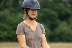 Reitstunde Fotografie Aloys Peter Trenz Frau mit Helm beim Reiten im Freien
