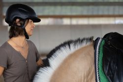 Reitstunde Fotografie Aloys Peter Trenz Frau bereitet Pferd mit schwarz-weißer Mähne für das Reiten vor