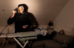 Storytelling Sorge Dich nicht lebe - The Day after Mann mit Bügeleisen als Telefon im Wohnzimmer