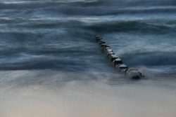 Sylt Fotografie Licht - Bewegung Oktober 2021 Holzpfosten am Strand bei rauer See in der Abenddämmerung