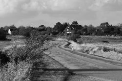 Sylt Fotografie Licht - Bewegung Oktober 2021 Ländliche Straße mit Häusern im Hintergrund, Schwarz-Weiß-Fotografie