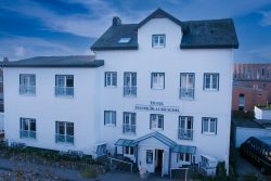 Sylt Fotografie Licht - Bewegung Oktober 2021 Drei-stöckiges Hotel Sylter Blaumuschel an einem wolkigen Tag