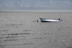 Sylt Fotografie Licht - Bewegung Oktober 2021 Einsames Boot auf ruhigem Meer unter bewölktem Himmel