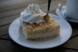 Sylt Fotografie Licht - Bewegung Oktober 2021 Käsekuchen mit Streuseln und Sahne auf einem Teller