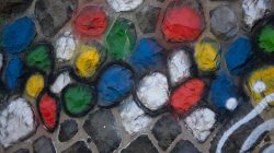 Urban Life und Streetfotografie Frankfurt Juni 2022 Bunte bemalte Steine in Mauer eingebettet