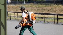 Urban Life und Streetfotografie Frankfurt Juni 2022 Gärtner mit Laubbläser arbeitet an einem sonnigen Tag im Freien