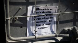 Urban Life und Streetfotografie Frankfurt Juni 2022 Iron fence mit Papier und Botschaft über Corona auf Deutsch