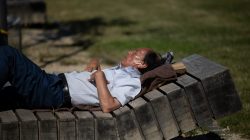 Urban Life und Streetfotografie Frankfurt Juni 2022 Älterer Mann entspannt auf einer Holzbank im Sonnenlicht