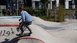 Urban Life und Streetfotografie Frankfurt Juni 2022 Skateboarder in kariertem Hemd im Skatepark auf Betonrampe