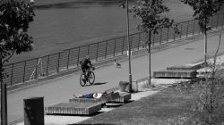 Urban Life und Streetfotografie Frankfurt Juni 2022 Radfahrer und liegender Mann an der Uferpromenade in schwarz-weiß
