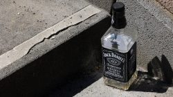 Urban Life und Streetfotografie Frankfurt Juni 2022 Leere Flasche Jack Daniels Whiskey auf Betonstufe bei Tageslicht