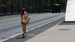 Urban Life und Streetfotografie Frankfurt Juni 2022 Frau auf Elektroroller auf Brücke in der Stadt